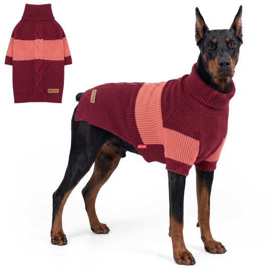 Doberman standing in burgundy and coral dog sweater with sleeves beside flat lay