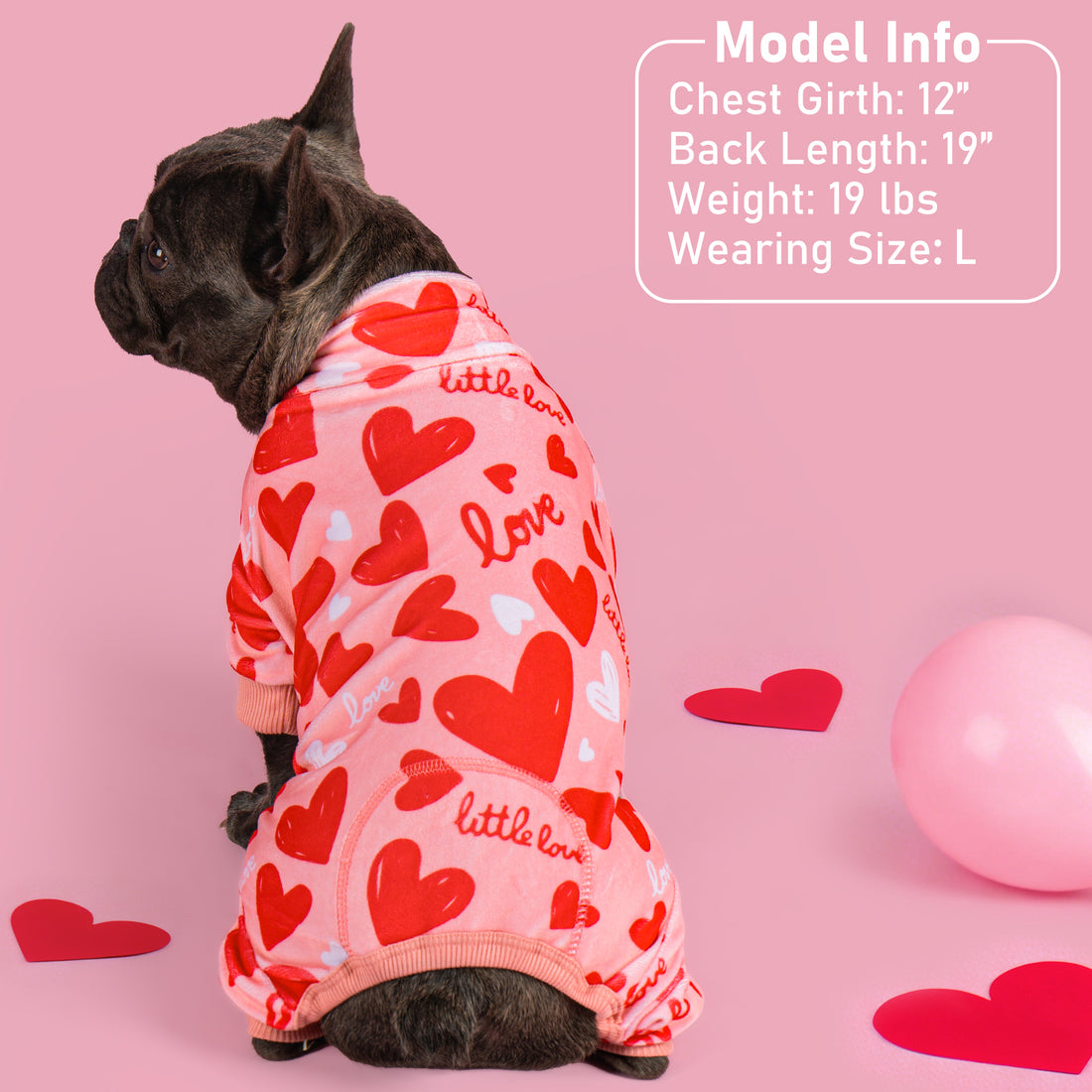 Heart-print dog onesie pajama with red-and-white body and pink ribbed leg openings