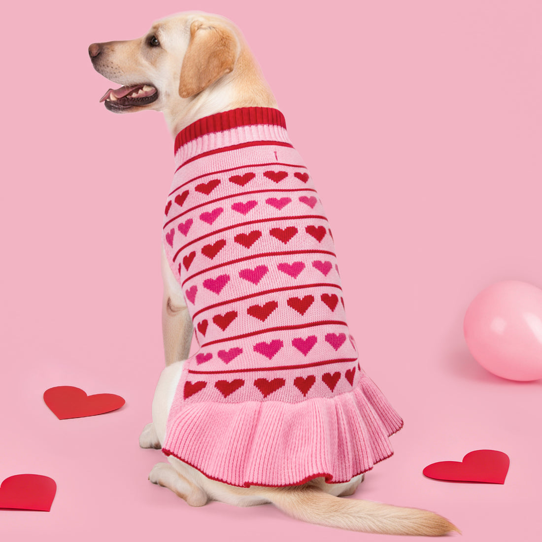 Pink dog sweater dress with red hearts, ribbed turtleneck, and ruffled hem