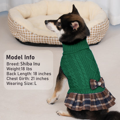 Dog wearing green cable knit turtleneck sweater with plaid ruffle hem and bow