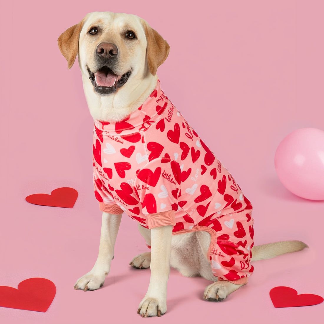 Dog onesie pajama with red heart pattern and pink ribbed collar and sleeve cuffs