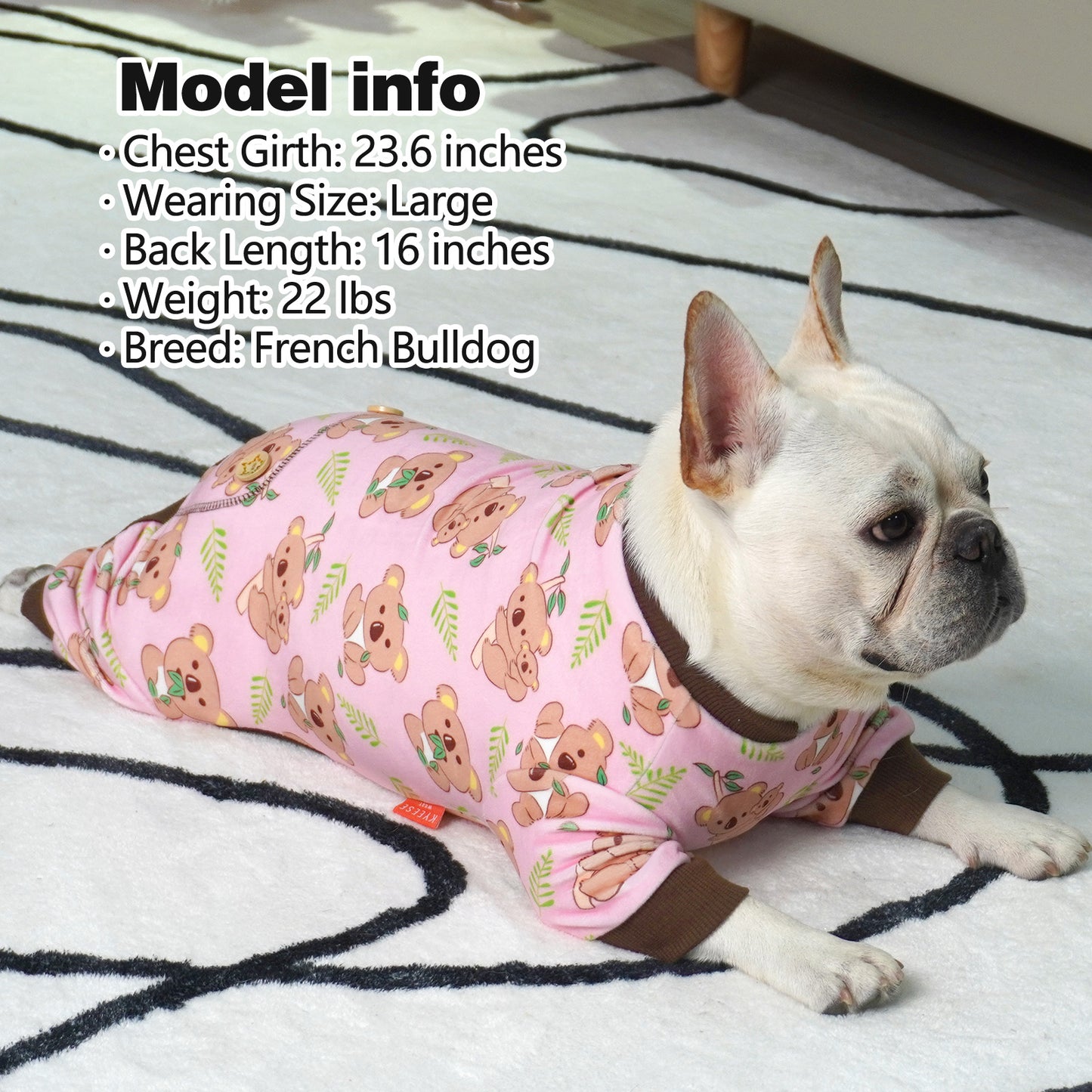 Pink dog onesie pajamas with cartoon puppy print and brown cuffs on small dog