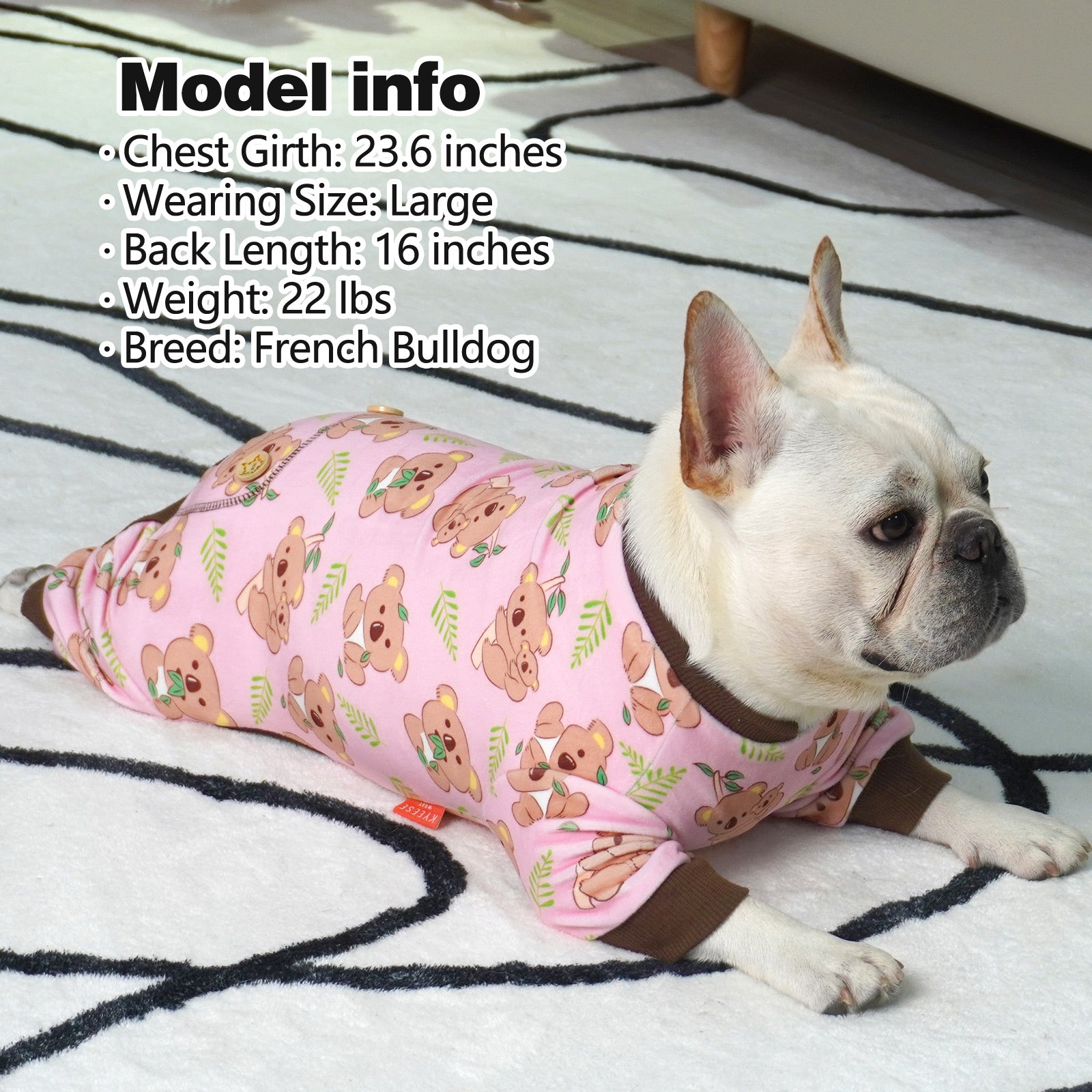 Pink dog onesie pajamas with cartoon puppy print and brown cuffs on small dog