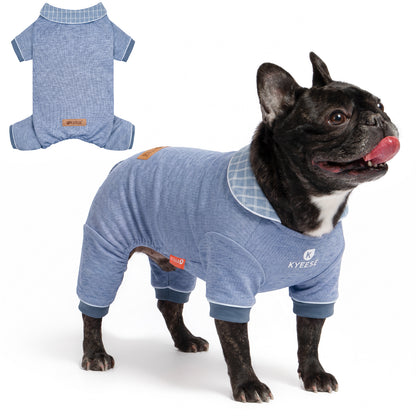 Small black French bulldog wearing blue collared thermal dog pajamas beside a flat lay