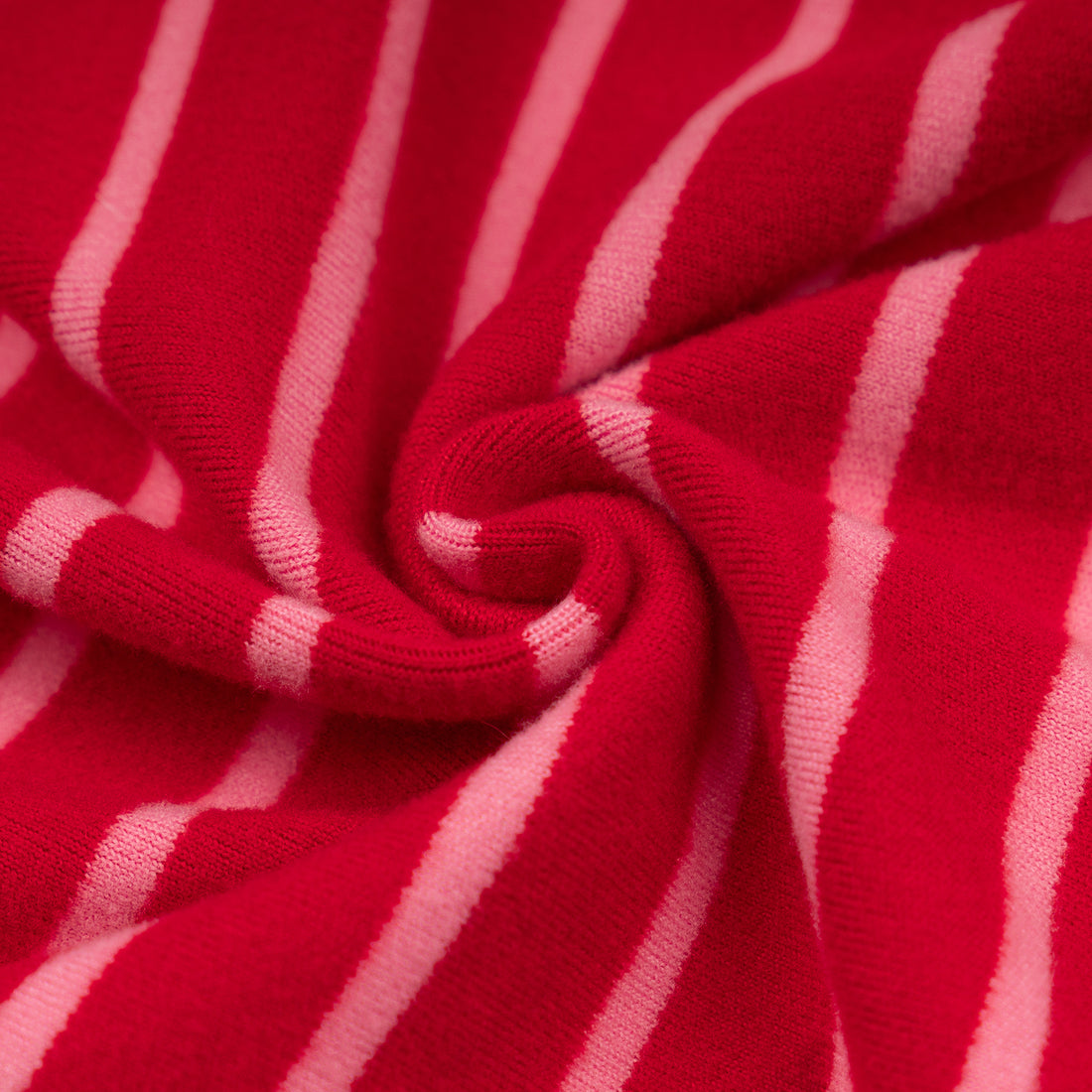 Red-and-white striped dog onesie pajamas fabric close-up with gathered knit