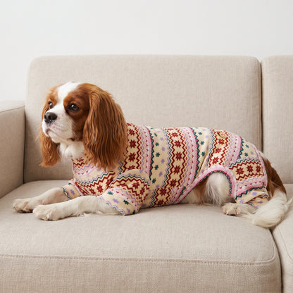 Pink Snowflake Dog Christmas Pajamas, cream and pink Fair Isle snowflake pattern, dog wearing the pajamas in a holiday or home setting